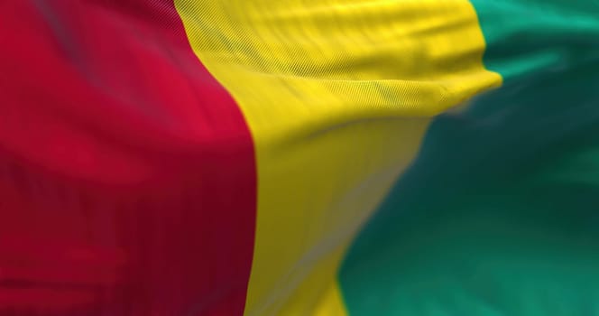 Detail of Guinea National flag waving. Republic of Guinea is a West African state. Rippled fabric. Textured background. Realistic 3d illustration. Close-up