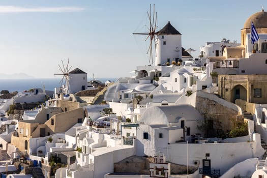 Oia, Santorini, Greece - June 28, 2021: Whitewashed houses and windmills in Oia on Santorini island, Cyclades, Greece
