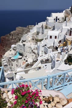 Oia, Santorini, Greece - July 3, 2021: Whitewashed houses with terraces and pools and a beautiful view in Oia on Santorini island, Greece