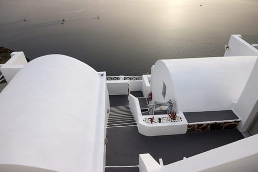 Imerovigli, Santorini, Greece - July 1, 2021: Whitewashed houses with terraces and pools and a beautiful view in Imerovigli on Santorini island, Greece