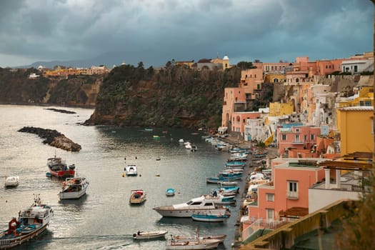 View of the Port of Corricella with lots of colorful houses on a sunny day in Procida Island, Italy.