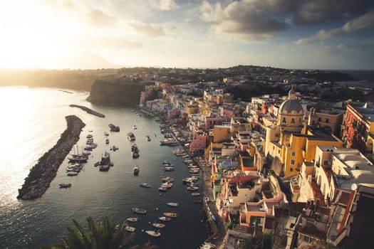 View of the Port of Corricella with lots of colorful houses in the sunset, Procida Island, Italy.