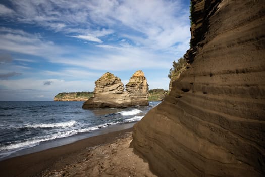 The black Ciraccio beach with the rock formations shaped by the wind on the northwest coast of the island of Procida in the Gulf of Naples