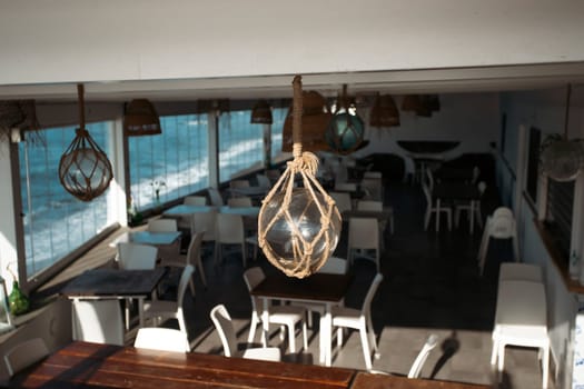 Cozy terrace on the beach, idyllic view of the seashore. Tropical summer vacation concept.
