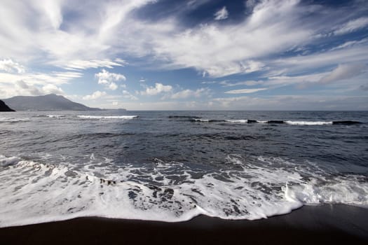 View of Ciraccio beach with black sand and clear water, Procida, Italy