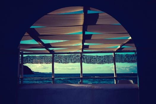 Cozy terrace on the beach, idyllic view of the seashore. Tropical summer vacation concept.