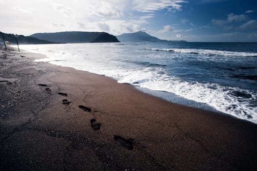 Footsteps in the sand on a beautiful italian beach.