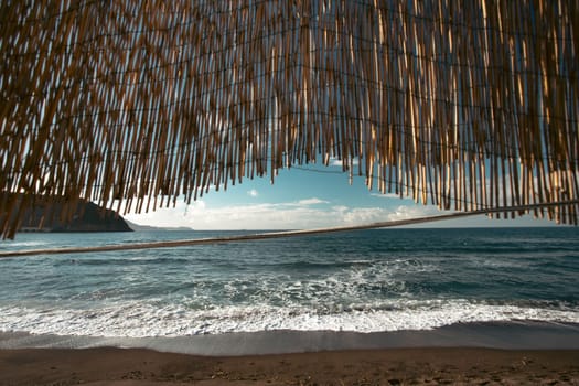 Cozy terrace on the beach, idyllic view of the seashore. Tropical summer vacation concept.