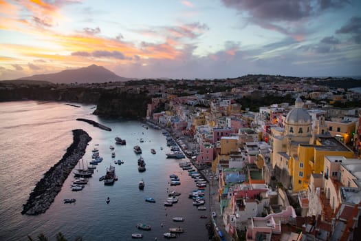 View of the Port of Corricella with lots of colorful houses in the sunset, Procida Island, Italy.