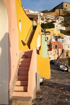 View of the Port of Corricella with lots of colorful houses on a sunny day in Procida Island, Italy.