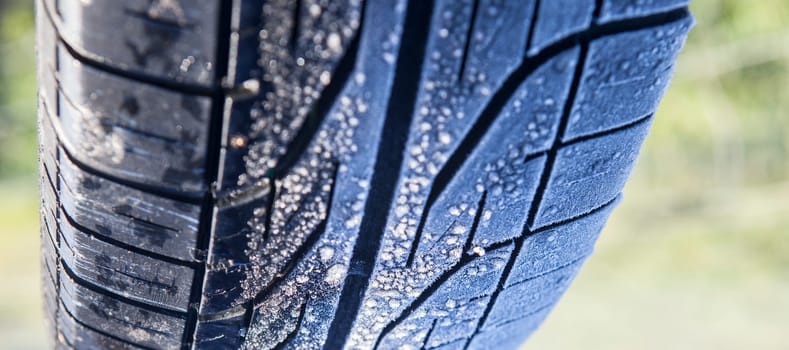 Frost covered tire surface. Safe driving on winter concept