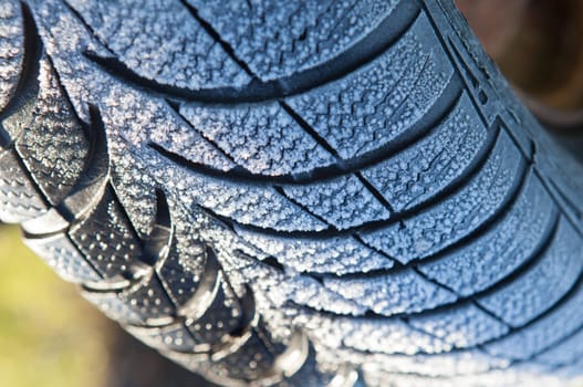 Frost covered tire surface. Safe driving on winter concept