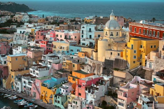 View of the Port of Corricella with lots of colorful houses in the sunset, Procida Island, Italy.