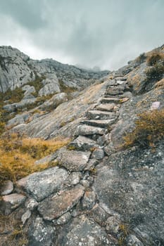 Andringitra national park, Haute Matsiatra region, Madagascar, beautiful mountain landscape with trail with stone stairs to high peak. Hiking in Andringitra mountains. Madagascar wilderness landscape.