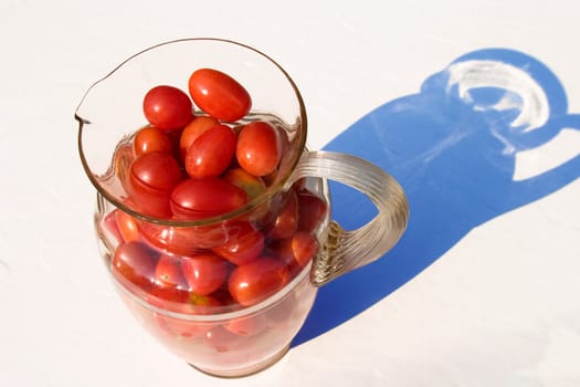 Cherry tomatoes in a glass pitcher.