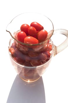 Cherry tomatoes in a glass pitcher.