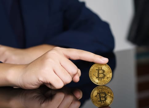 Close-up of finger touching golden bitcoin coin. Cryptocurrency and future money concept