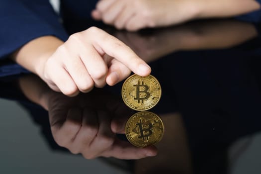 Close-up of finger touching golden bitcoin coin. Cryptocurrency and future money concept