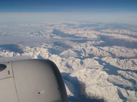 Jet engine with snowcapped alps in background