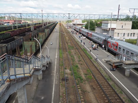 Svir, Russia, August 6, 2021. Railway station top view. People get off the trains. District railway station of the Oktyabrskaya railway. Docking station for two types of electric traction.