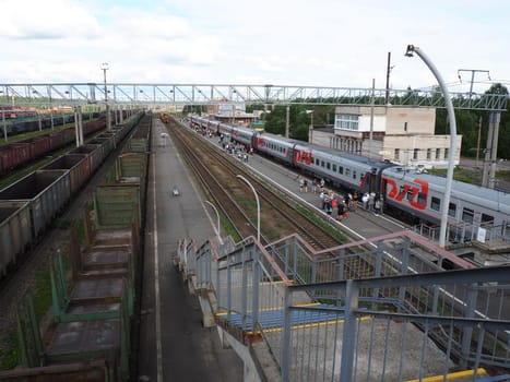 Svir, Russia, August 6, 2021. Railway station top view. People get off the trains. District railway station of the Oktyabrskaya railway. Docking station for two types of electric traction.