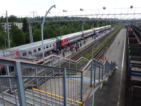 Svir, Russia, August 6, 2021. Railway station top view. People get off the trains. District railway station of the Oktyabrskaya railway. Docking station for two types of electric traction.