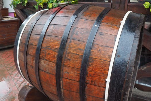 A traditional old wooden barrel with curved walls and metal hoops. Dishes for the ripening of alcoholic beverages - mead, beer, wine, whiskey. A rollable cylindrical vessel for liquid substances