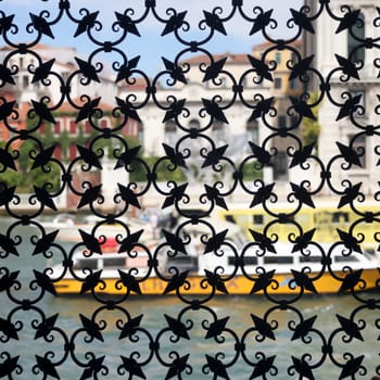 Detail of an ancient window with grating in wrought iron. Venice, Italy