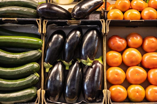 Colorful organic summer bio vegetables, tomatoes, zucchini and eggplant in boxes being sold on local fruit and vegetables market