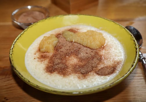 A plate of porridge, applesauce, and cinnamon and sugar.