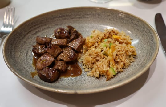 Beef with rice on a plate.
