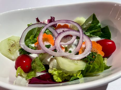 A salad plate full of a mixed salad and beautiful onion rings.
