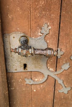 A cast iron old door handle on a solid wooden door.
