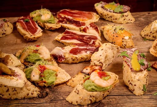 Many bites with cheese and ham in a tapas bar.