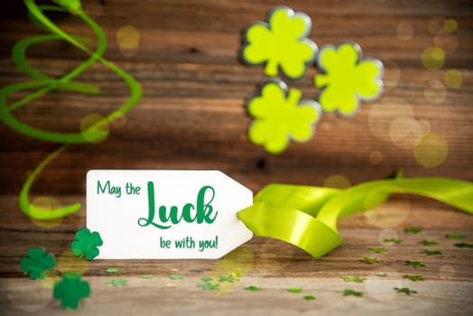 White Label With English Text May Be The Luck With You. Saint Patrick's Day Decoration With Green Shamrock And Clover. Wooden Vintage Background With Festive Ribbon.
