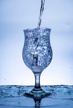 The image of pouring drinking water, into a glass, that makes one feel refreshed on blurred white background, Splashing water, Sparkling water
