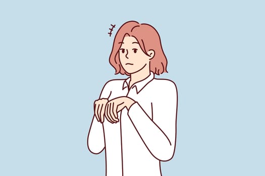 Young girl stands like puppy or bunny, bending palms near chest in pose symbolizing obedience and humility. Attractive woman in white shirt looks at screen in embarrassment