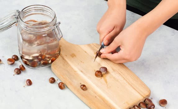 Preparing chestnut liquid soap, cutting buckeye and putting it into a jar with water, alternative homemade detergent for washing clothes