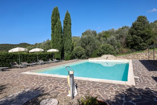 A swimming pool on the Montemassi hillside surrounded by cypresses and oleanders n the province of Grosseto. Italy