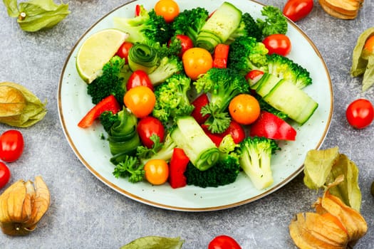 Fresh salad with broccoli, tomato, cucumber and physaliswinter cherry . Food background