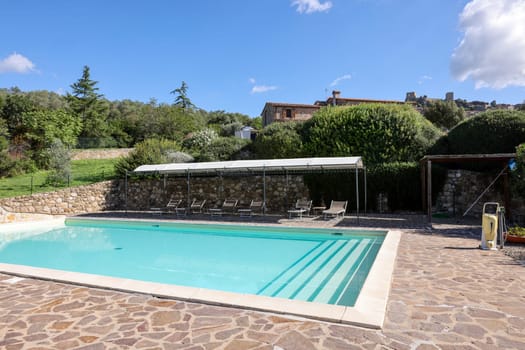 A swimming pool on the Montemassi hillside surrounded by cypresses and oleanders n the province of Grosseto. Italy