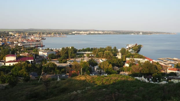 Kerch August 21, 2021 View of the city of Kerch from the observation deck on Mount Mithridat. Houses, trees, Black and Azov seas, seaport. Cove and opposite shore with horizon. Summer evening.