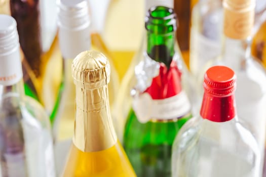 Full and empty bottles of different alcoholic drinks, abuse and alcohol addiction. Alcoholism concept.