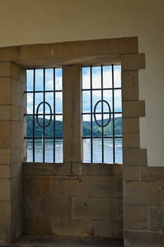 View through a barred window at the Staudam on the Eder lake in Germany
