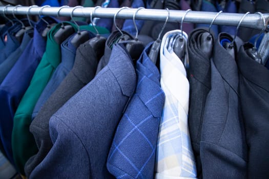 Men's clothing on hangers in a shop, closeup of photo