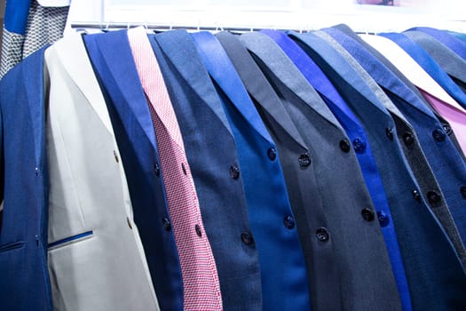 Men's clothing on hangers in a shop, closeup of photo