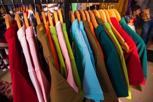 Colorful clothes on hangers for sale in a market in Paris, France