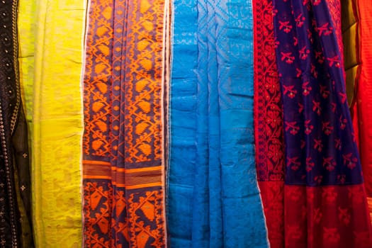 Bangladeshi Women's Traditional Colorful Jamdani saree hanging in the retail Showrooms. Colorful Jamdani Saree Texture Background