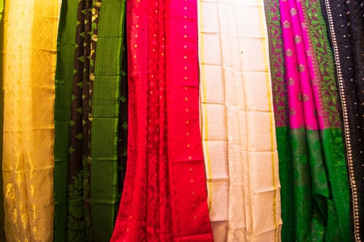 Bangladeshi Women's Traditional Colorful Jamdani saree hanging in the retail Showrooms. Colorful Jamdani Saree Texture Background