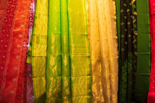 Bangladeshi Women's Traditional Colorful Jamdani saree hanging in the retail Showrooms. Colorful Jamdani Saree Texture Background